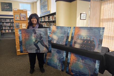 Elizabeth Cooke-Sumnu shows off a panel with text and images from an exhibition on the Amherst Royals